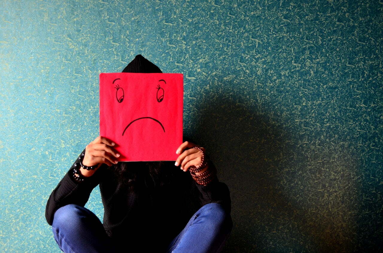 Man Holding Sad Face in Front of Him