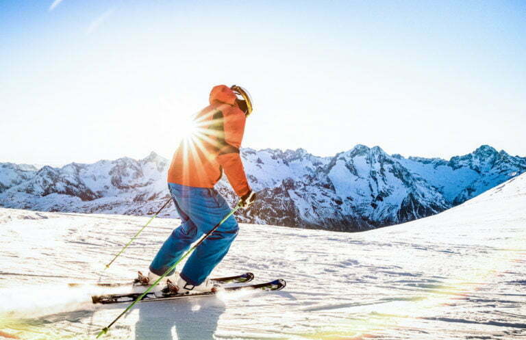 Professional skier athlete skiing at sunset on top of french alp
