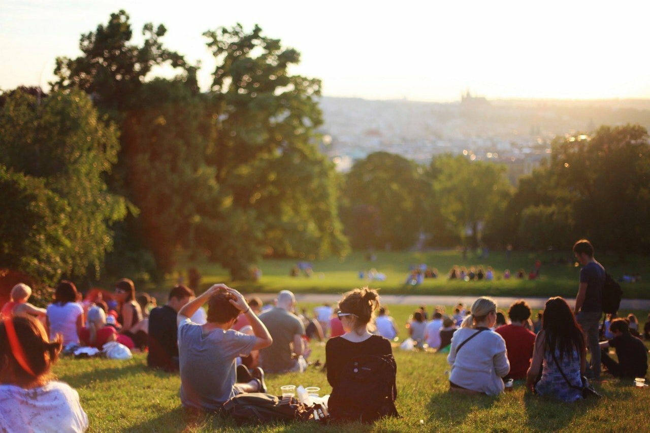 a group of people sitting in a circle in a park