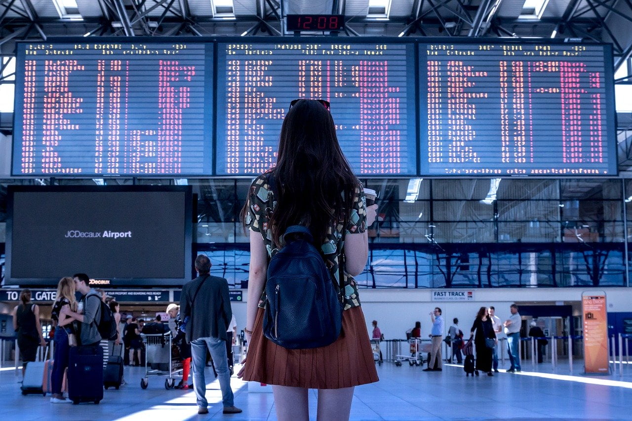 a woman standing in front of a large screen with people in the background