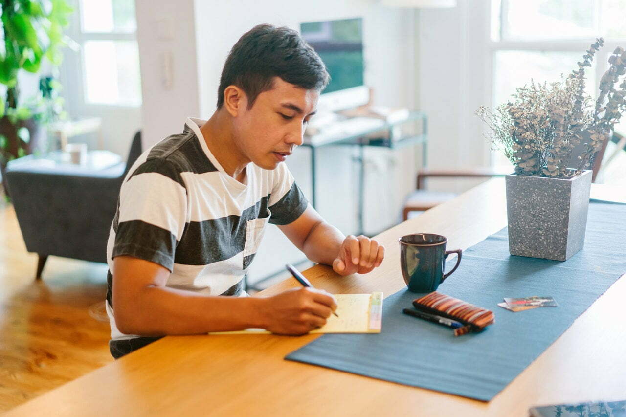 a person writing on a piece of paper