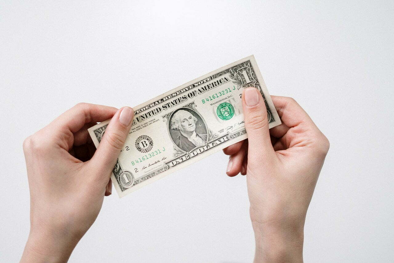 a person holding a fanned out dollar bills
