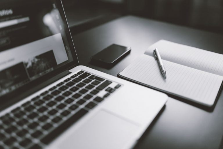 a laptop and a pen on a table