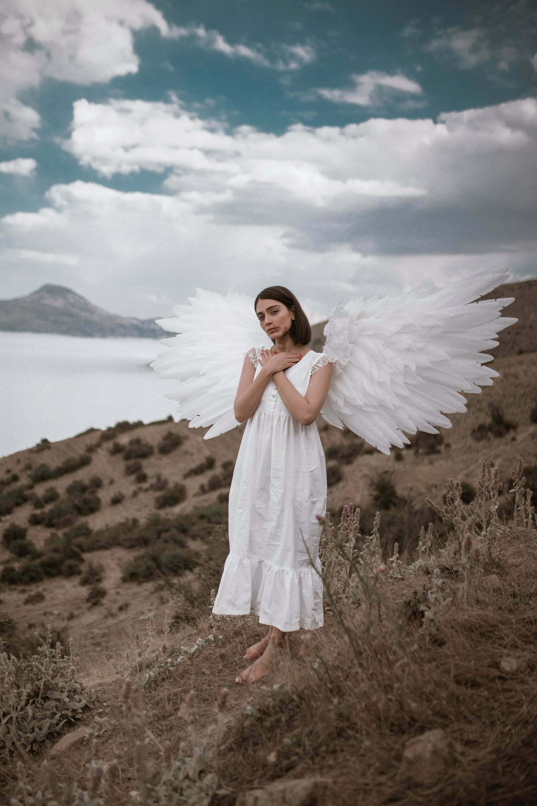 a person in a white dress standing on a beach