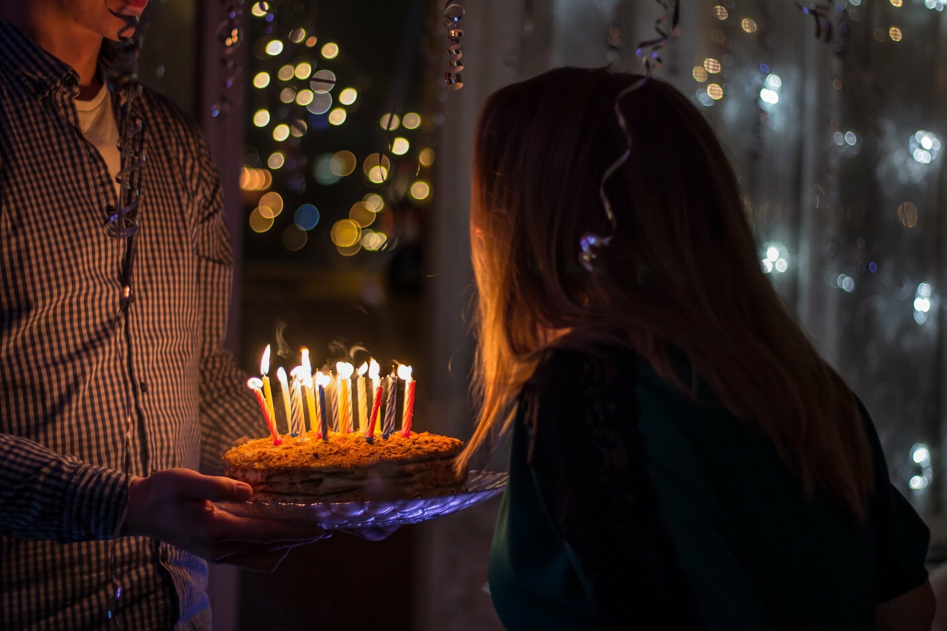 a woman lighting a candle on a cake