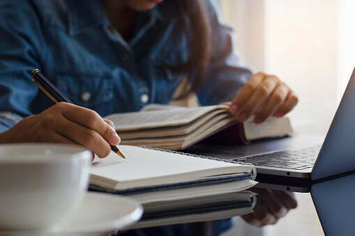 a person writing on a piece of paper