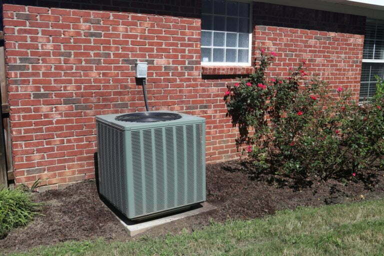 a grey trash can outside of a brick building