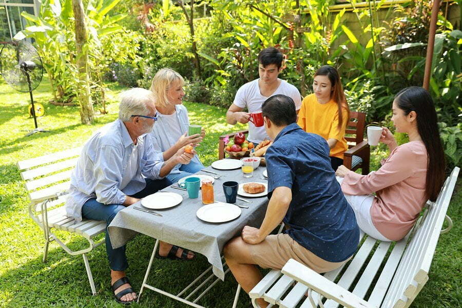 a group of people sitting around a table outside