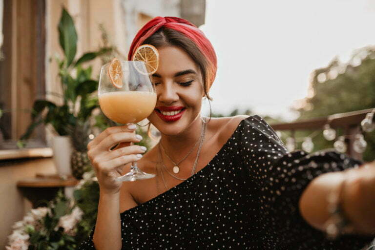Pretty modern lady with silver accessories, cute smile and bright bandana in black polka dot clothe