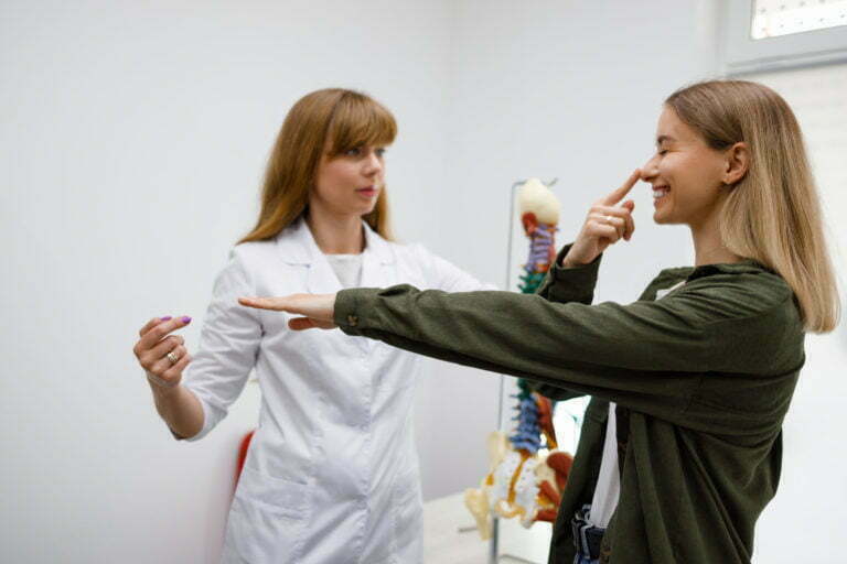 Neurologist performing neurological tests on young female patient.